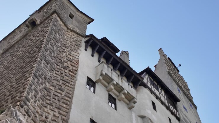 Vista esterna del Castello di Bran che mostra le mura in pietra, le piccole finestre e gli elementi strutturali in legno