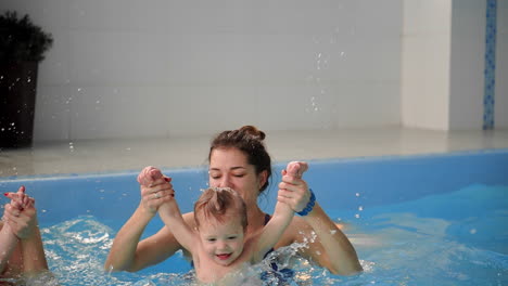 familia sana madre enseñando al bebé piscina de natación