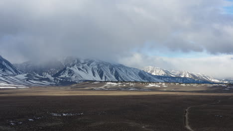 Vista-Panorámica-Aérea-De-Las-Nubes-Sobre-Las-Montañas-Nevadas-Del-Este-De-Sierra-Nevada,-California,-Estados-Unidos