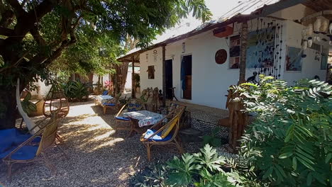 House-in-Bubaque-with-the-floor-covered-in-white-shells,-trees-and-armchairs-for-relaxing