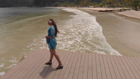 a woman walks out on a jetty on the most famous beach maracas located on the north coast of trinidad