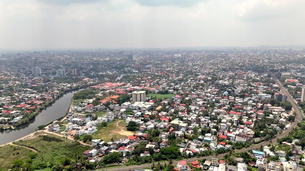 Video drone pemandangan kota pusat Ernakulam dengan pembangunan perkotaan yang berkembang, jalan-jalan yang dipenuhi pepohonan, pemandangan tepi sungai, dan perpaduan dinamis arsitektur modern dan keindahan alam