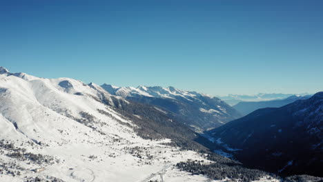 Cinematic-Aerial-View-of-Snowy-Mountain-Valley