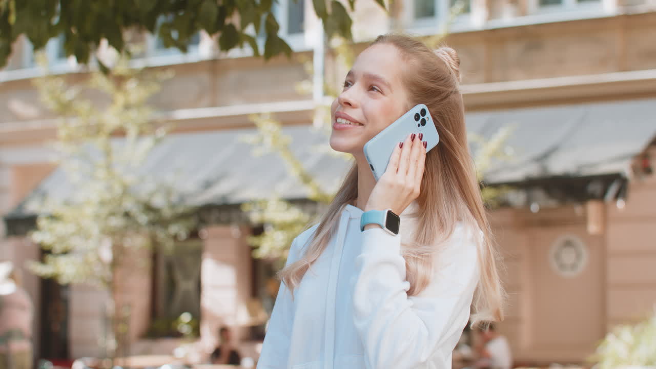 кавказская туристка ведет дистанционный разговор общается с помощью смартфона на городской улице