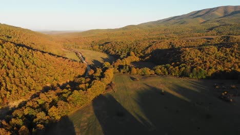 Aerial-drone-shot-of-grass-fields-and-forests-at-sunset-1