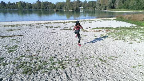 disparo de drones de una joven y atractiva mujer negra haciendo deportes al aire libre