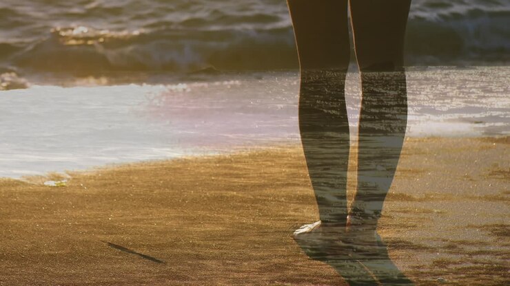 Donna in piedi a piedi nudi sulla spiaggia