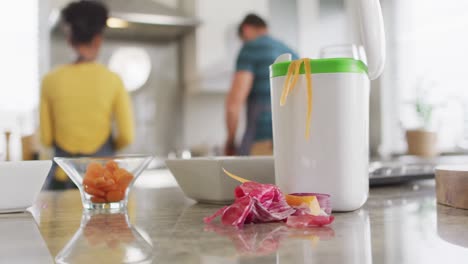 video de un contenedor con cáscaras y restos de vegetales de pie en la encimera de la cocina