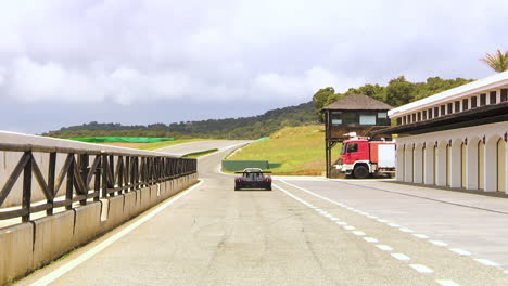 static shot: racing car drives out of the box onto the racetrack