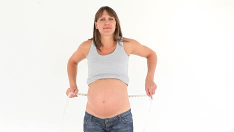 pregnant woman measuring her belly