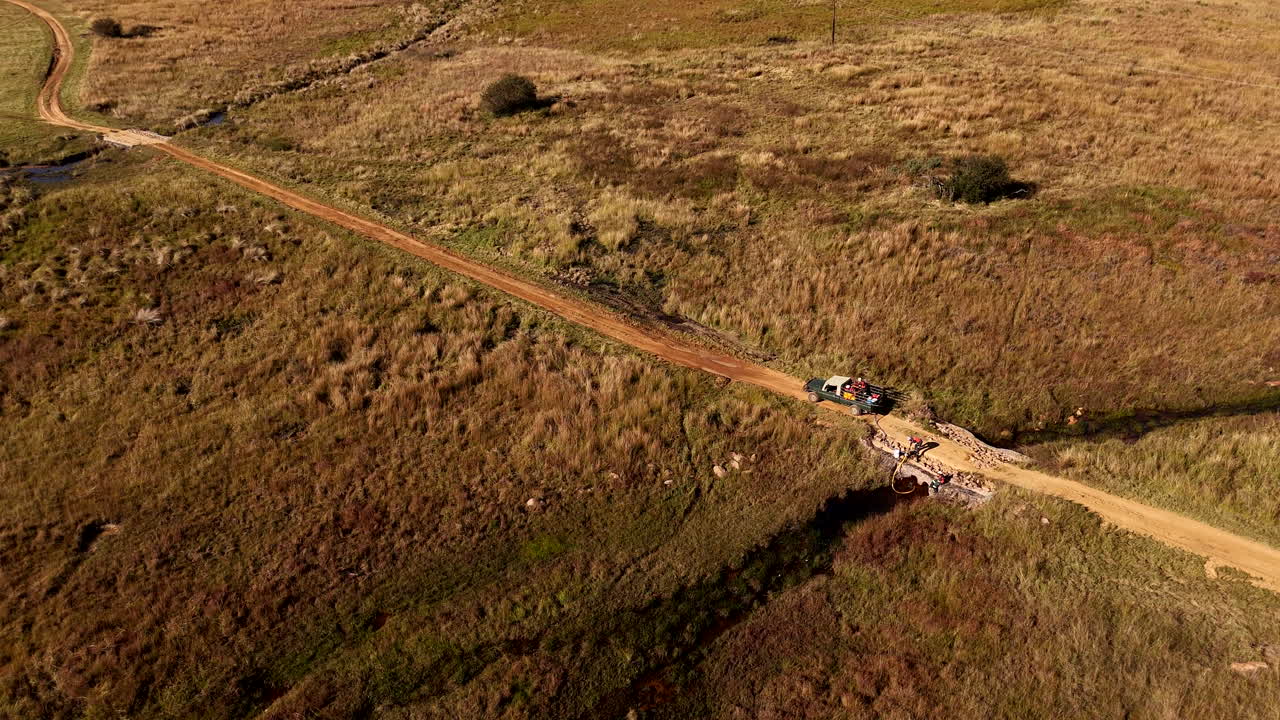 Drone view of workers filling fire fighting water tank on truck from stream
