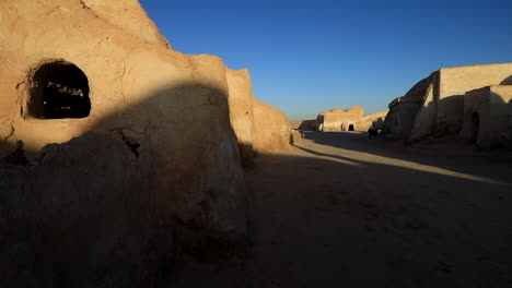 early morning light casts shadows on an old star wars desert set, creating a serene yet eerie mood, wide shot