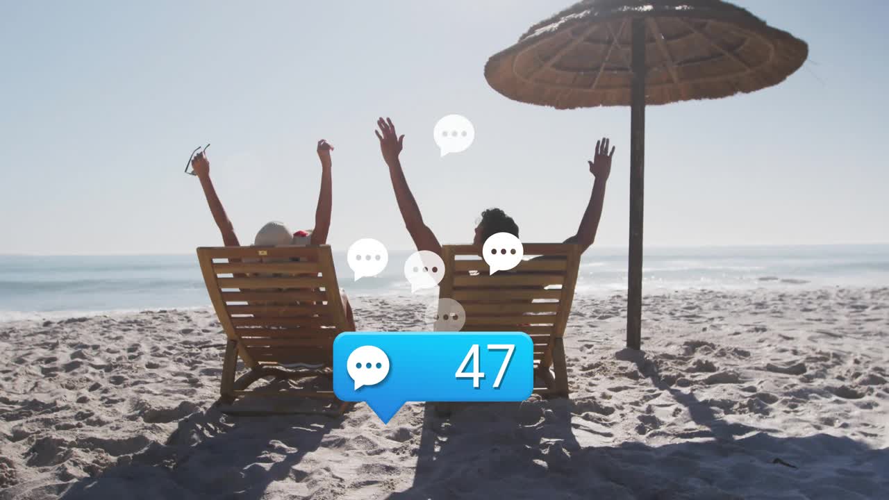 Pareja de marketing recostada bajo una sombrilla de playa, celebrando mientras el icono de chat multiplica las notificaciones.