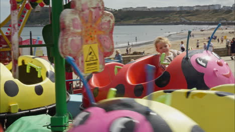 happy little girl rides on a carousel amusement park ride