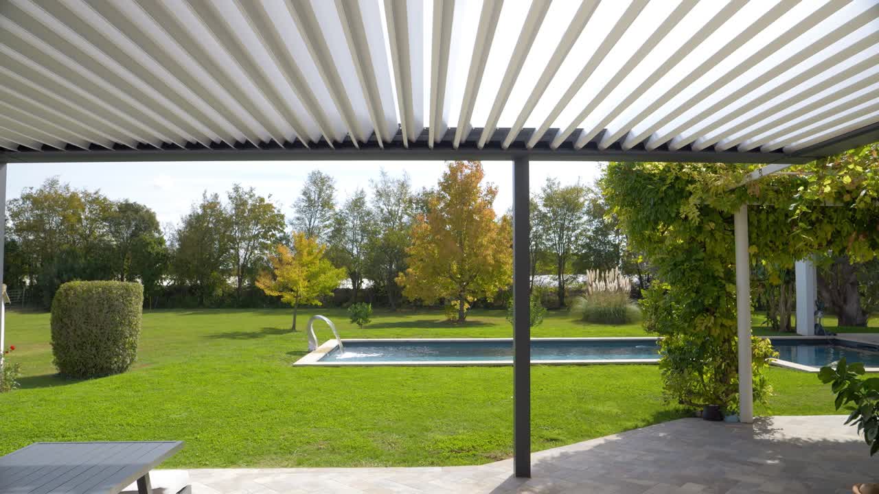 disparo de inclinación en cámara lenta de una piscina privada y una sombrilla abierta en una villa