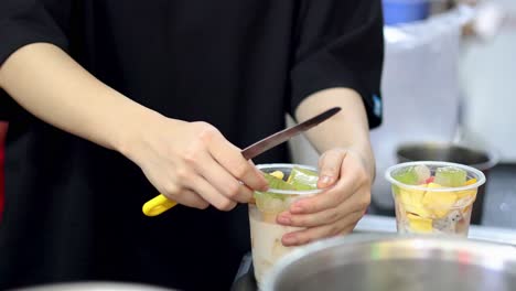 cutting and arranging fruit in a cup