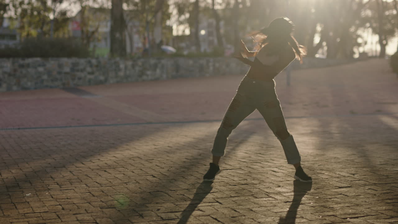bailarina joven bailarina de hip hop en la ciudad disfrutando de frescos movimientos de baile de estilo libre urbano practicando expresión al atardecer