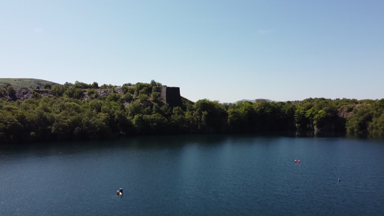 вид с высоты на уэльскую лесную долину, карьерное озеро, шахту по добыче сланца, горы сноудония