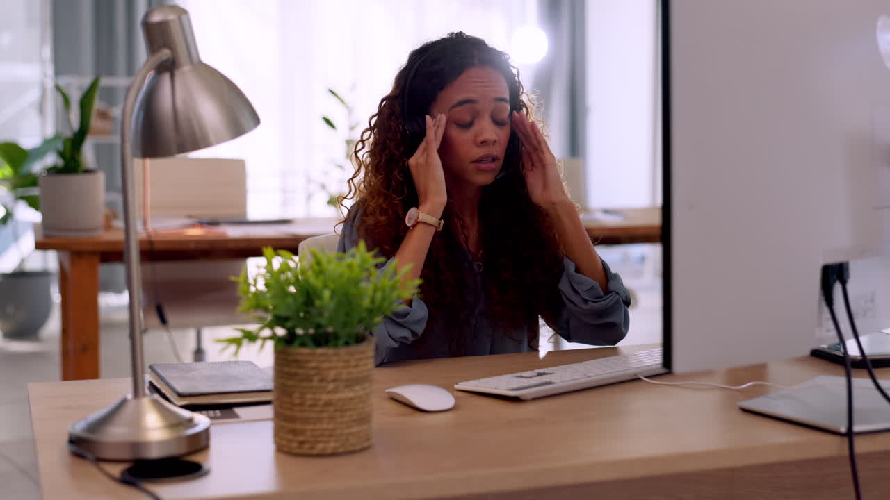 Femme de bureau devant son ordinateur avec un mal de tête