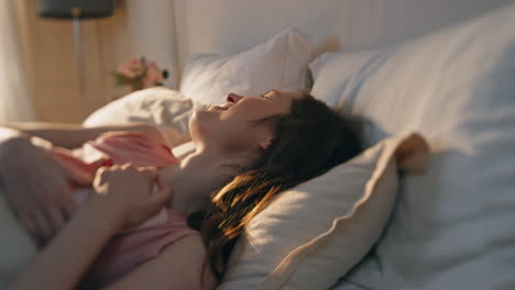 joyful girl resting bed in morning sunlight closeup. happy woman waking up early