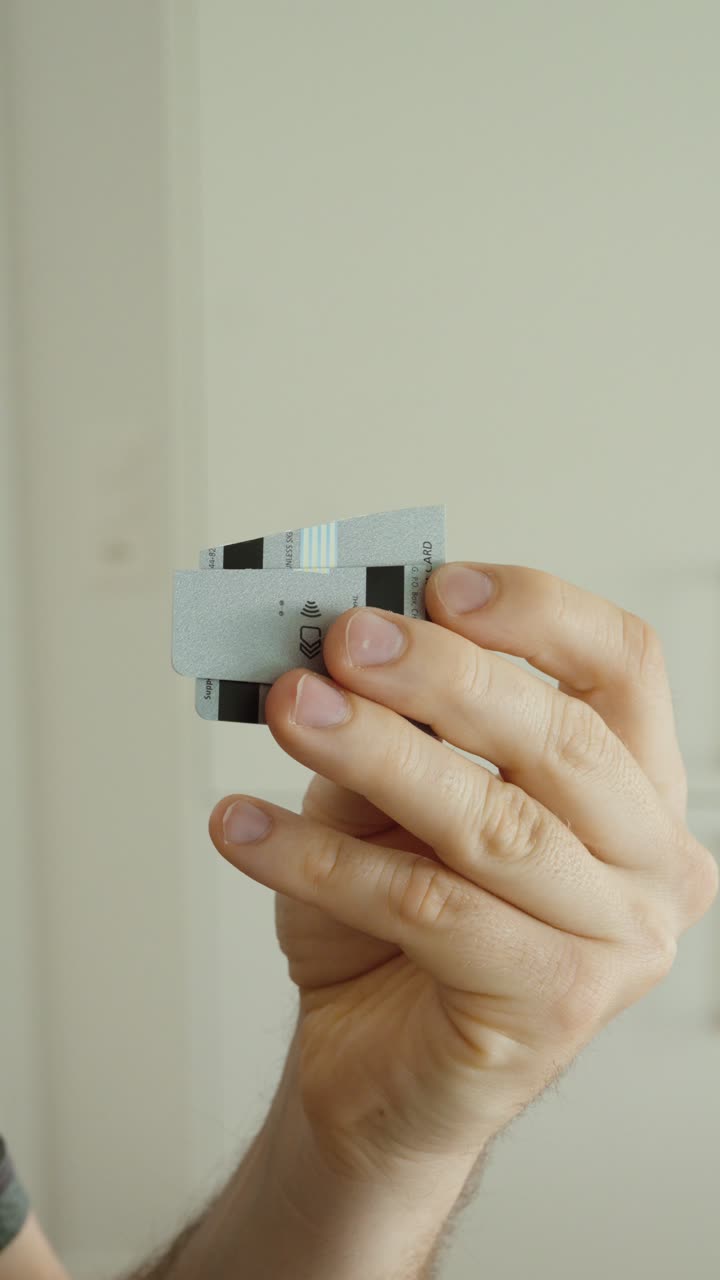 Close-up of a hand holding a cut credit card, symbolizing account closure, financial control, fraud prevention, and data protection. Ideal for banking, finance, and security concepts