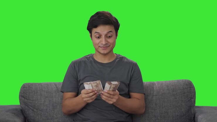 hombre indio feliz contando dinero pantalla verde