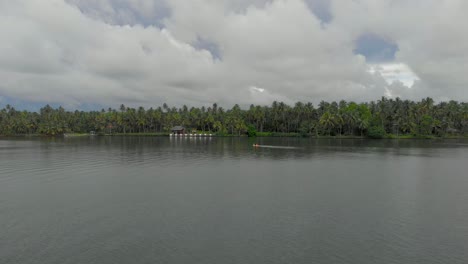 4k-Aerial-Hyperlapse-of-a-28-year-old-Indian-Male-paddling-a-Kayak-in-the-backwaters-of-Varkala-surrounded-by-coconut-trees-around,-Kerala