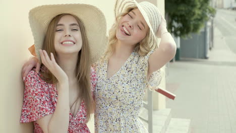 two women in summer dresses and straw hats