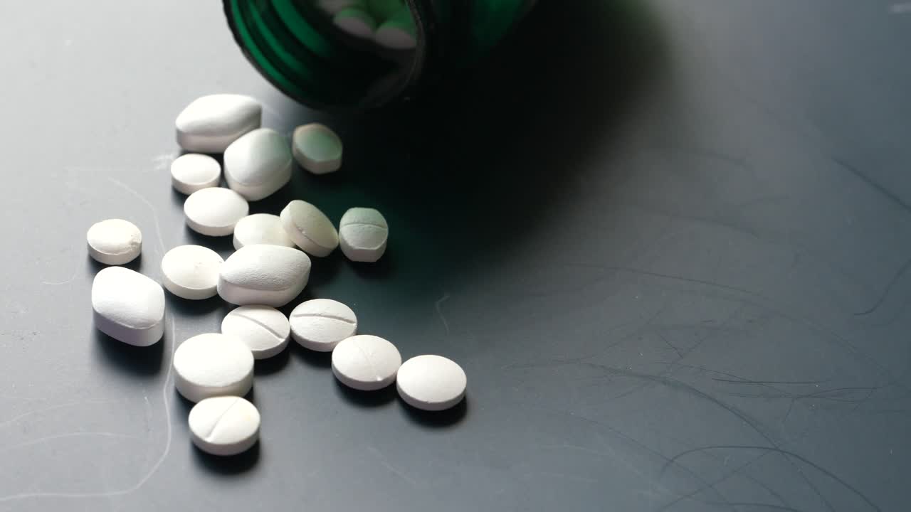 회색 표면에 어져 있는 색 알약