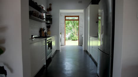 modern kitchen with sleek appliances and open door leading to lush garden, at home
