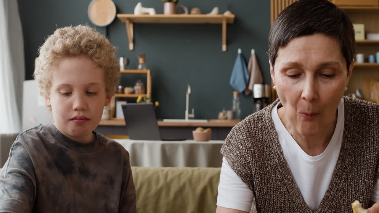 Mother and Son Snacking and Drinking at Home