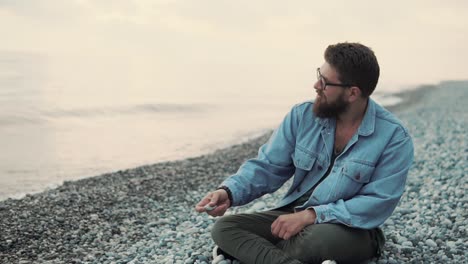 man sitting on the beach at sunset