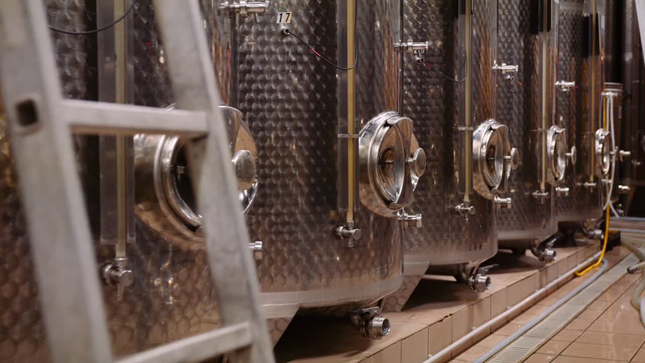 tiro de camión a lo largo de tanques de acero inoxidable en bodega utilizada para la fermentación del vino