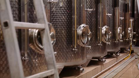 trucking shot along stainless steel tanks in cellar used for wine fermentation