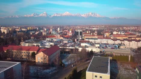 aerial view of a city with snow-covered mountains in the background