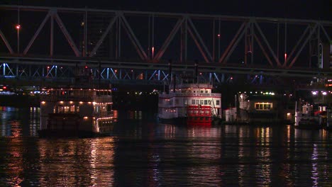 la luz se refleja en el río ohio con el fondo de la ciudad de cincinnati ohio cuando un barco fluvial pasa por debajo 2