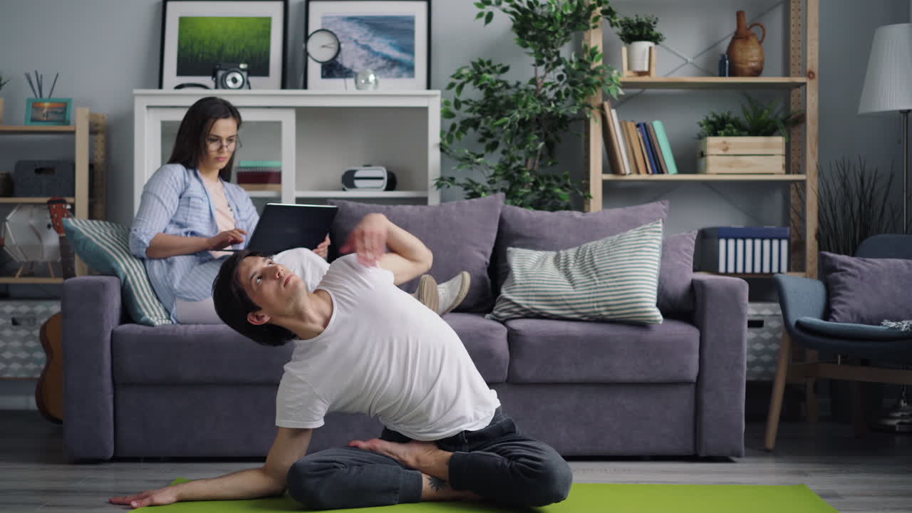 Couple doing yoga and working from home