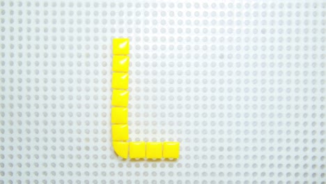 stop-motion-of-the-letter-U-creating-one-pixel-at-the-time,-made-with-children-toys