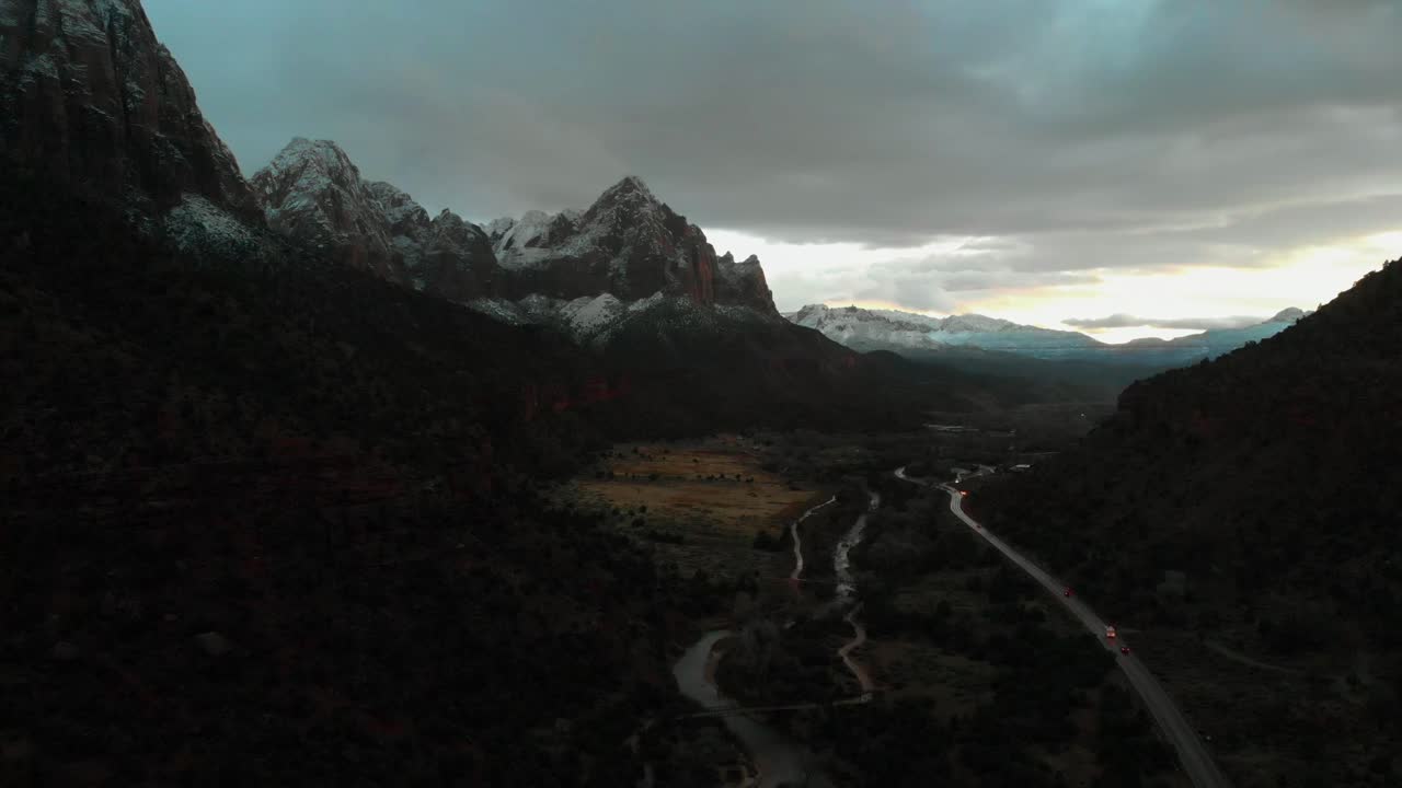 Aerial shot of a stunning snow covered mountain peak during sunset near Zion National park.