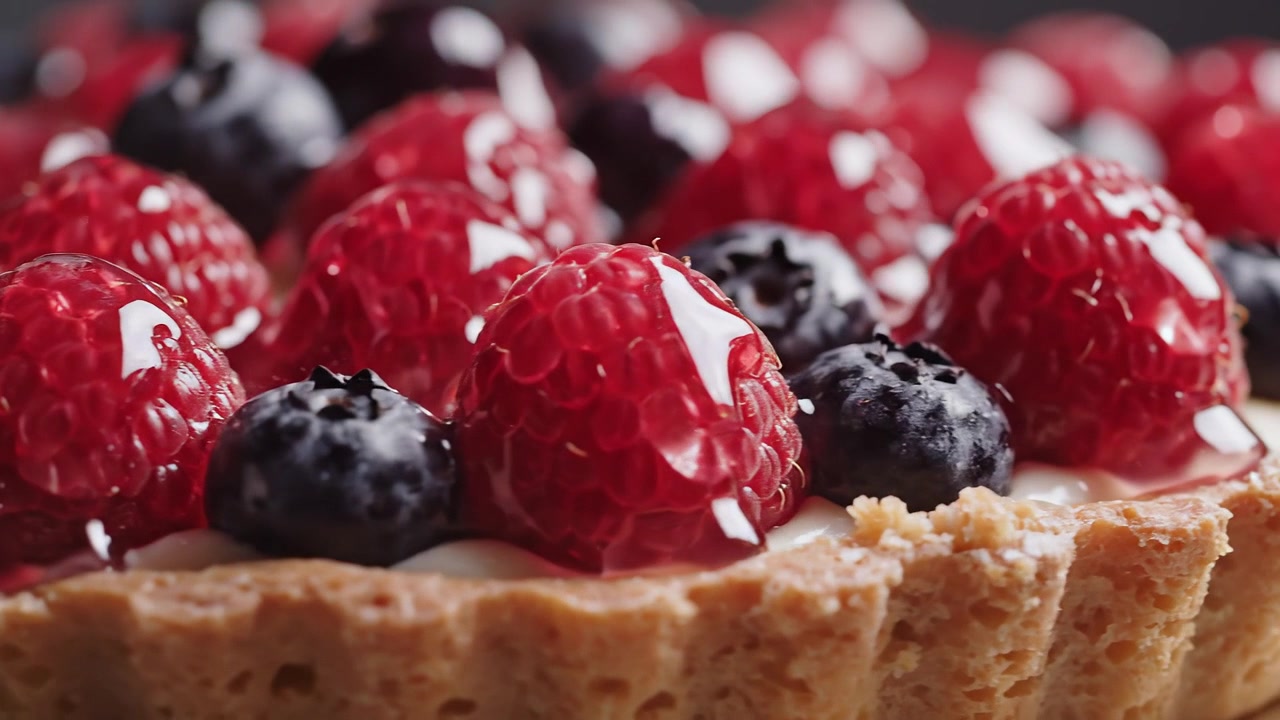 Fresh raspberry and blueberry tart with glossy glaze close-up