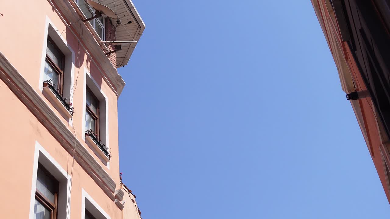 Salmon-colored building facade against a clear blue sky