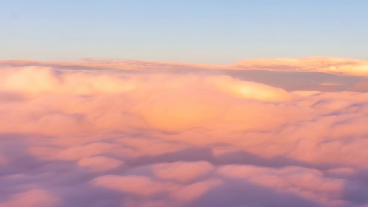 Soft layered clouds fill the sky with gentle pastel tones as warm sunlight illuminates the scene, creating a calm and scenic atmospheric backdrop