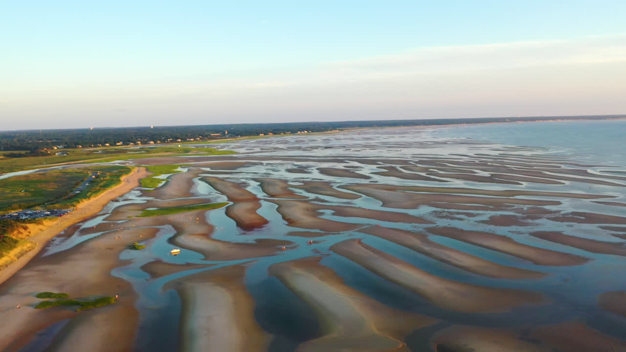 imágenes aéreas de drones de la bahía de cape cod de la playa durante la marea baja con gente caminando, barras de arena y charcos durante la hora dorada