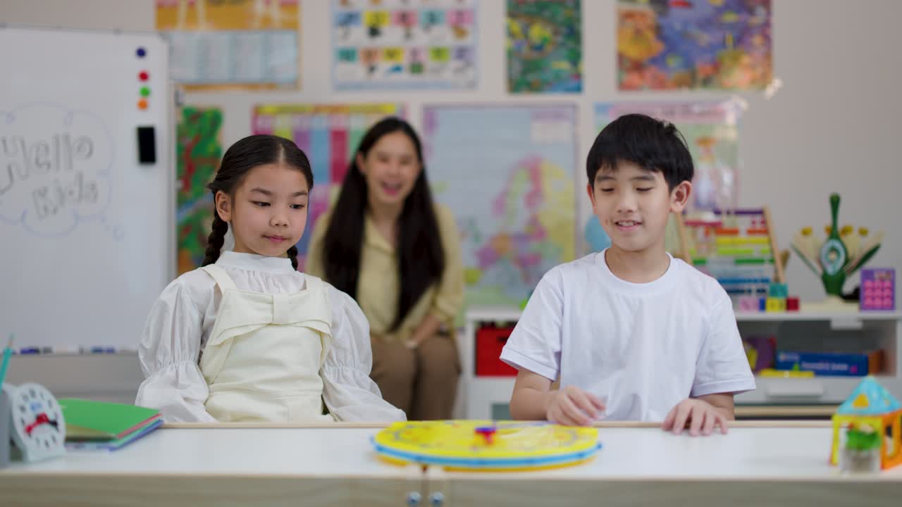 Two children interact with a toy clock, learning time concepts in a bright classroom setting