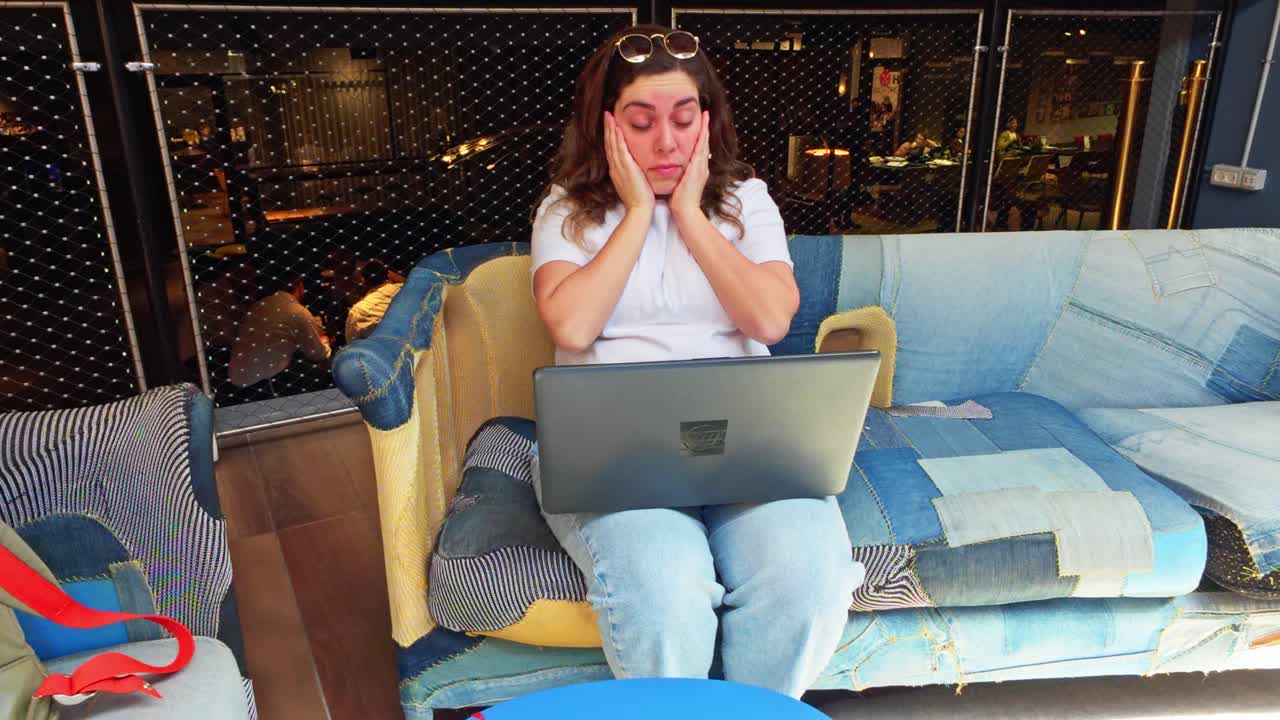 Student feeling tired yawning while working on laptop