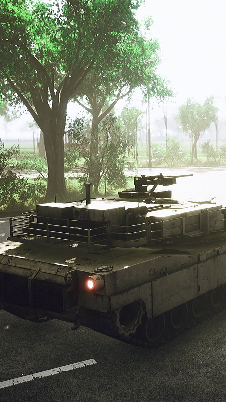 Tank moving on a road surrounded by trees during daylight hours