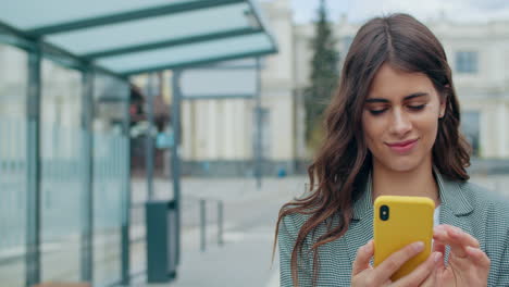 young woman using smartphone at bus stop