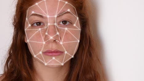 primo piano di una giovane donna con i capelli rossi, con una camicia bianca su sfondo bianco, con animazione ad alta tecnologia di riconoscimento facciale con punti di tracciamento e un effetto bagliore sul viso