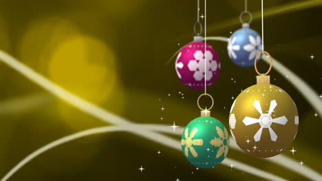 spinning colourful christmas baubles and white stars over curves and yellow boke lights, copy space