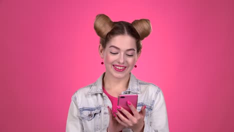 woman using mobile phone in a pink studio environment